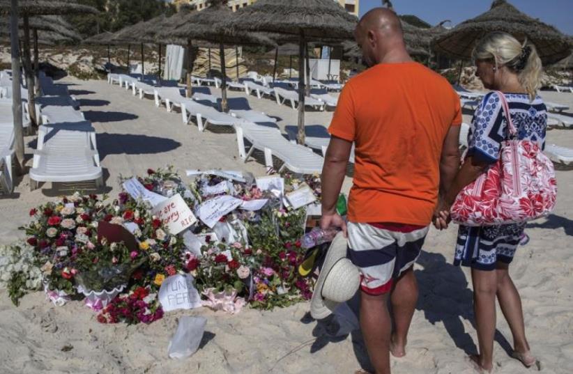 Tourists in front of a makeshift memorial to the victims of the terror attack at the Sousse beach resort, Tunisia, June 29. (photo credit: ZOHRA BENSEMRA/REUTERS)
