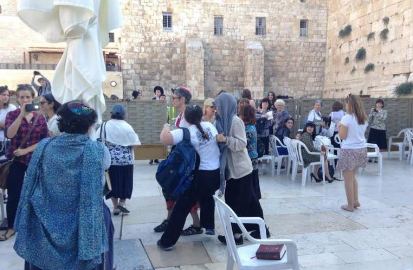 Women of the Wall supporter Ella Rembrand (center) pushes back against orthodox woman (photo credit: SHANA MEDEL)