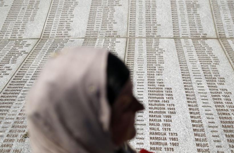 A woman stands in front of the Memorial Center during a reburial ceremony of 136 newly identified victims in Potocari, near Srebrenica, Bosnia and Herzegovina (photo credit: REUTERS)