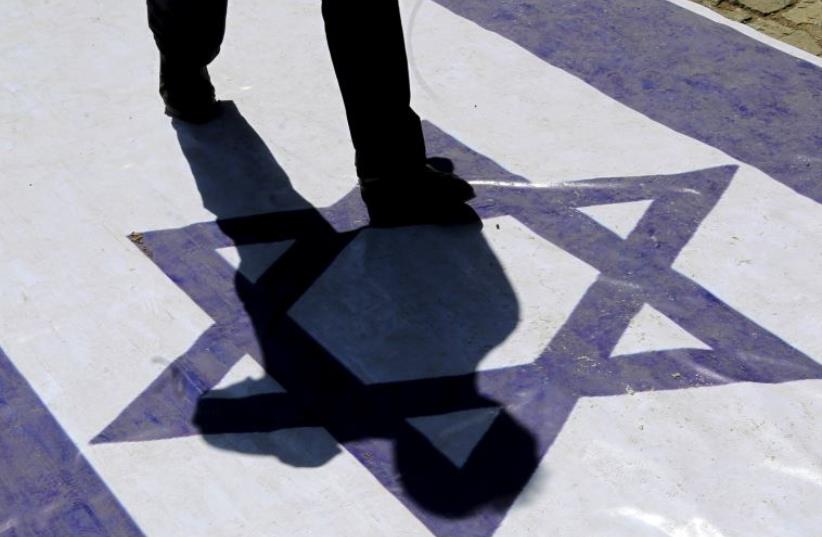 A demonstrator steps on an Israeli flag during a rally marking al-Quds (Jerusalem) Day in Tehran (photo credit: REUTERS)