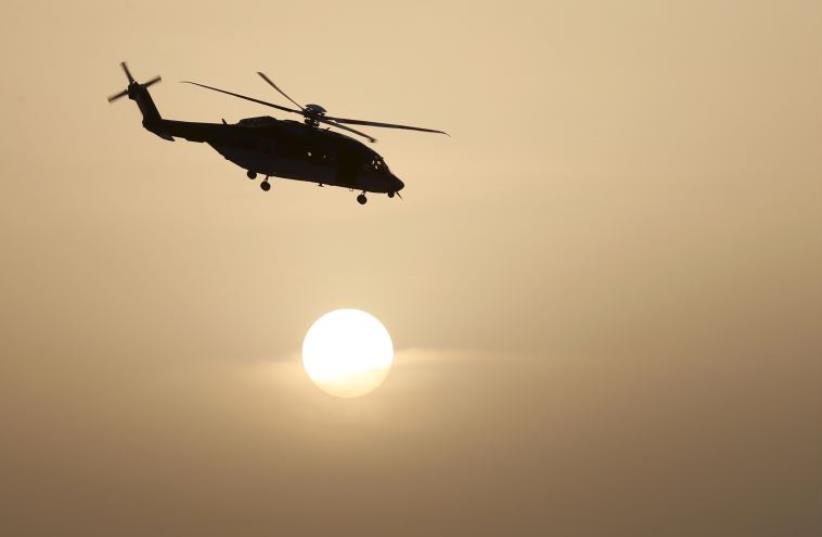 A helicopter of Saudi special forces flies near the setting sun during a graduation ceremony held in Riyadh (photo credit: REUTERS)