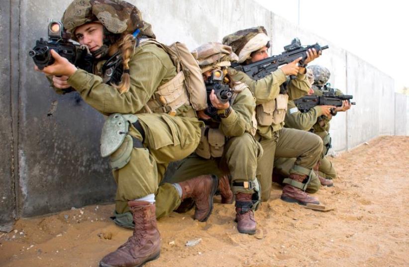Female combat soldiers in the mixed-gender Caracal Battalion train in urban warfare. (photo credit: IDF SPOKESMAN’S UNIT)