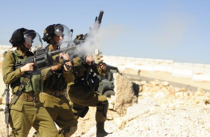 A Home Front Command soldier fires an automatic grenade launcher during training (photo credit: IDF SPOKESMAN’S UNIT)