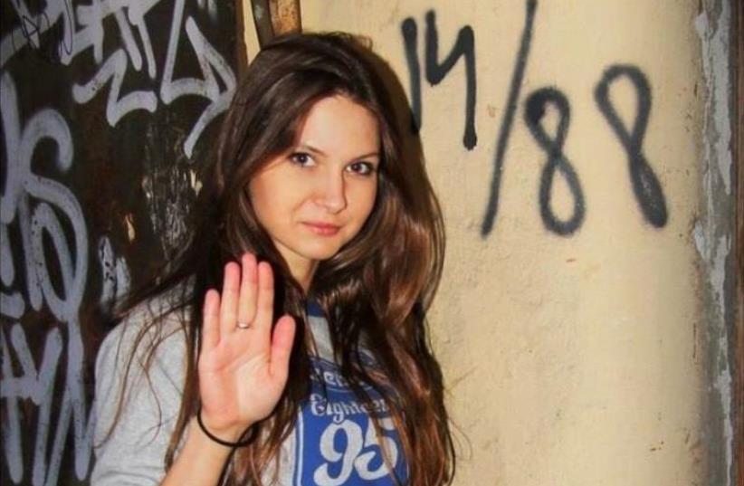 Olga Kuzkova was photographed posing in front of graffiti reading “14/88,” a coded message among white supremacists (photo credit: VKONTAKTE‏)