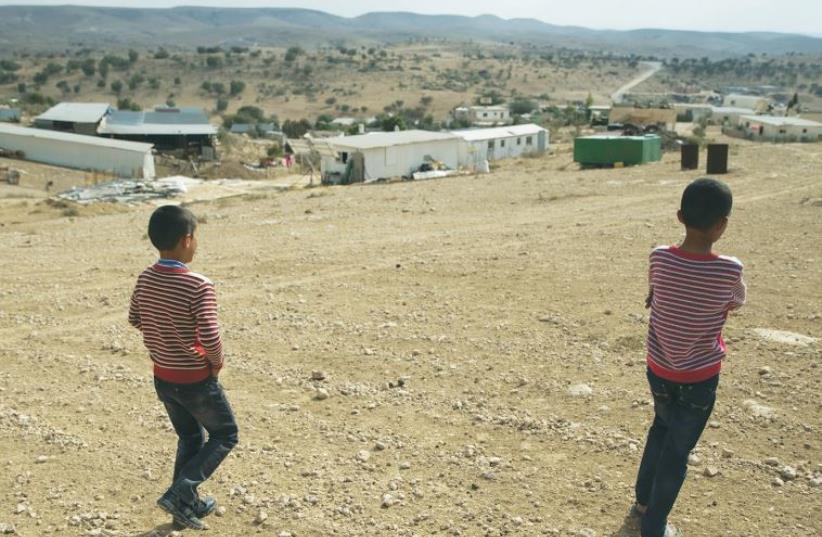 BEDUIN BOYS walk toward the ‘unrecognized’ village of Um Al-Hiram in the Negev. (photo credit: REUTERS)