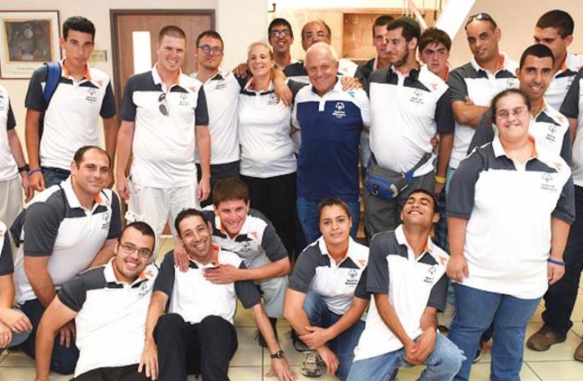 Members of Israel’s delegation to the Special Olympics World Games pose for a photo with Minister of Welfare and Social Services Haim Katz (center in blue) prior to their departure for Los Angeles (photo credit: AVI HAYUN)
