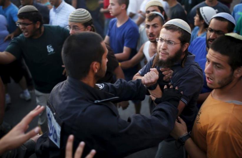 Jewish settlers (R) scuffle with Israeli police officers near buildings slated for demolition by order of Israel's high court in Beit El (photo credit: REUTERS)