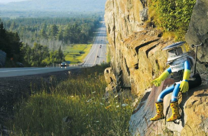Hitchbot, the hitchhiking robot, on Highway 17 in Ontario, Canada. (photo credit: KENNETH ARMSTRONG/REUTERS)