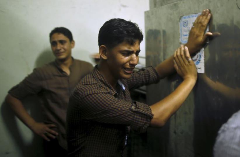 Friends of Palestinian teen Mohammed Al-Masri, 17, whom medics said was shot and killed by Israeli forces, mourn at a hospital morgue in the northern Gaza Strip (photo credit: REUTERS)