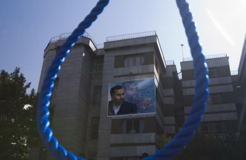 A picture of a murdered Iranian judge is seen through a noose before the hanging of his killers in Tehran (photo credit: REUTERS)