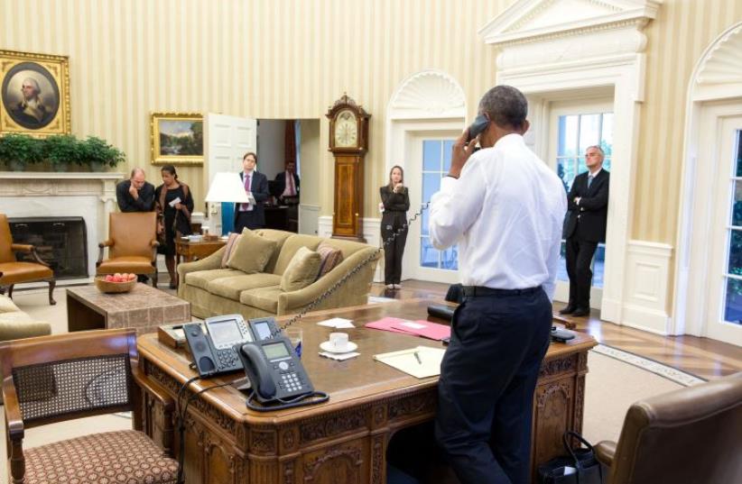 President Barack Obama talks on the phone in the Oval Office with Secretary of State John Kerry to thank him for his work with the negotiations on the nuclear agreement with Iran (photo credit: OFFICIAL WHITE HOUSE PHOTO / PETE SOUZA)