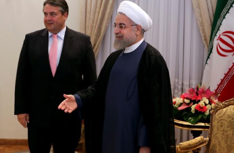 Germany vice chancellor and economic affairs minister Sigmar Gabriel with Iran president Hassan Rouhani (photo credit: ATTA KENARE / AFP)