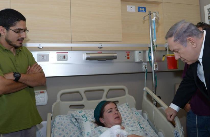 Prime Minister Benjamin Netanyahu visits terror victim at Haddasah Universty Medical Center in Jerusalem's Ein Kerem (photo credit: AMOS BEN GERSHOM, GPO)