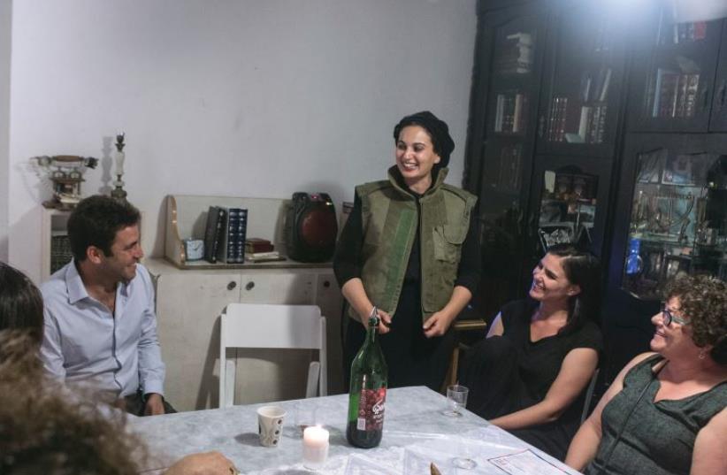 Marlyn Vinig (standing) is ‘At Home’ at the head of her table, flanked by Deputy Mayor Ofer Berkovitch (left). (photo credit: YAIR MOSS)