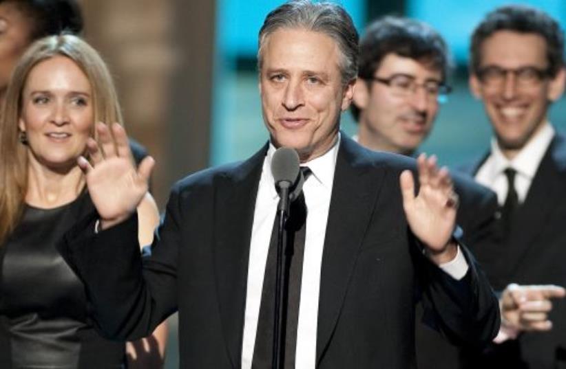 Talk show host Jon Stewart, flanked by his writers and correspondents, speaks after receiving the Best Late Night Comedy Series Award for his show (photo credit: REUTERS)