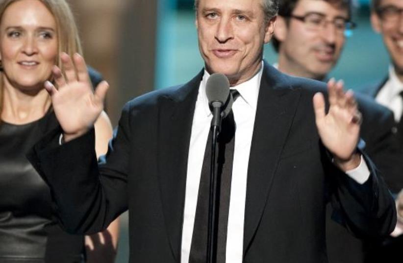 Talk show host Jon Stewart, flanked by his writers and correspondents, speaks after receiving the Best Late Night Comedy Series Award for his show (photo credit: REUTERS)