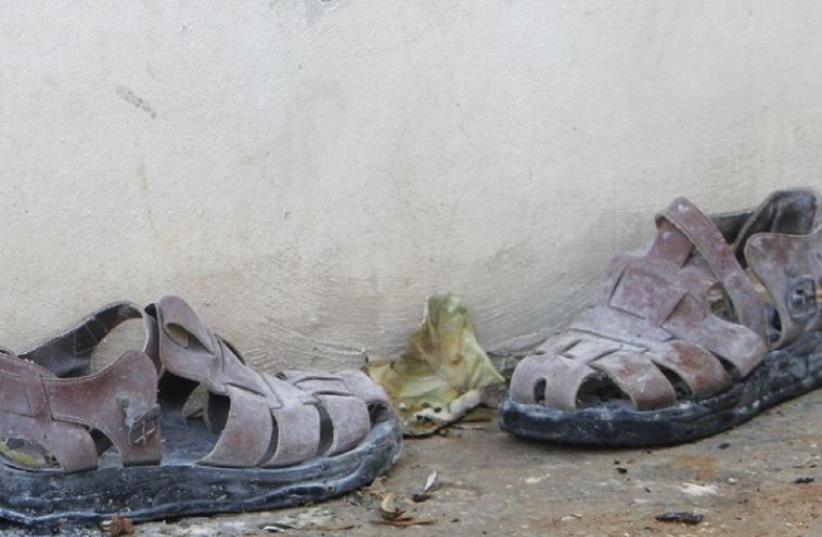 A PAIR of slippers is seen outside a house that had been torched in a suspected attack by Jewish extremists in Duma. (photo credit: REUTERS)