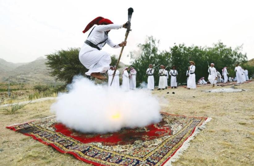 A man fires a weapon as he dances during a wedding celebration near the western Saudi city of Taif, last week. (photo credit: MOHAMED AL HWAITY/REUTERS)