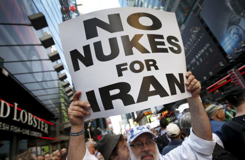 A man holds up a sign as he and several thousand other protestors demonstrate during a rally opposing the nuclear deal with Iran in Times Square (photo credit: REUTERS)