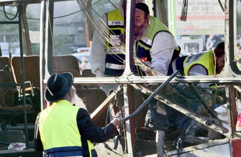 Israeli rescue workers search a bus destroyed by a suspected Palestinian suicide bomber in Jerusalem, June 11, 2003 (photo credit: REUTERS)