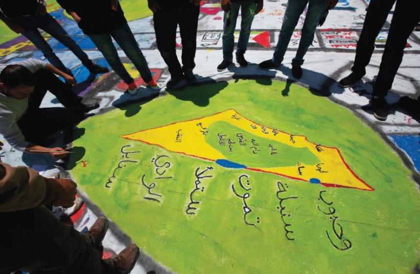 A PALESTINIAN draws a map showing the British Mandate of Palestine in the West Bank city of Ramallah in 2013. (photo credit: REUTERS)