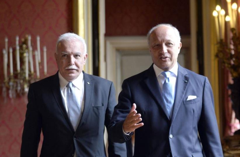 French Foreign Affairs minister Laurent Fabius (R) welcomes his Palestinian counterpart Riyad Al-Malki (L) (photo credit: MIGUEL MEDINA / AFP)