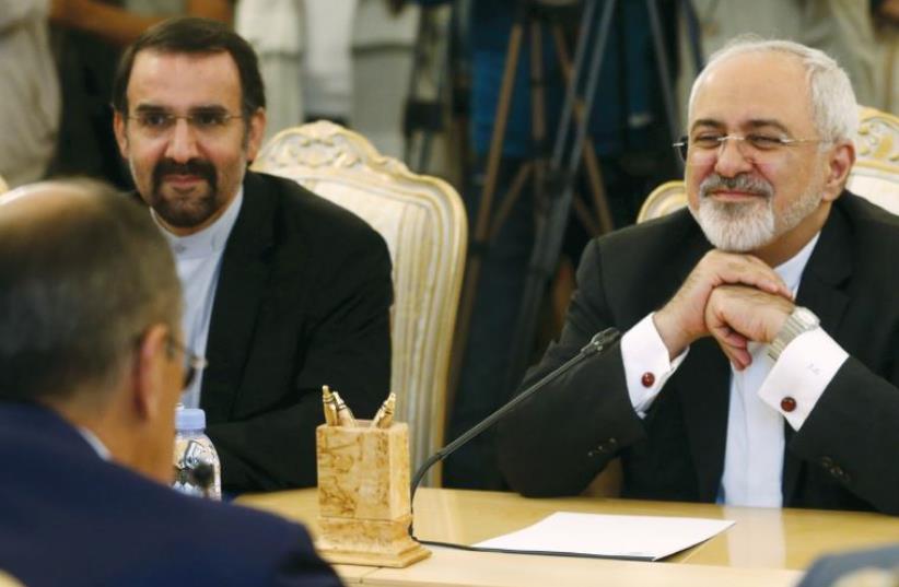 Iranian FM Mohammad Javad Zarif (right) listens to his Russian counterpart Sergei Lavrov (back facing) during their meeting in Moscow, Russia, (photo credit: MAXIM ZMEYEV/REUTERS)