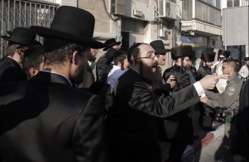 Police break up a demonstration by Ultra-Orthodox Jews against the desecration of the Sabbath in central Jerusalem (photo credit: AHMAD GHARABLI / AFP)
