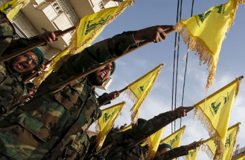Lebanon's Hezbollah members carry Hezbollah flags during the funeral of Adnan Siblini, who was killed while fighting in Syria (photo credit: REUTERS)