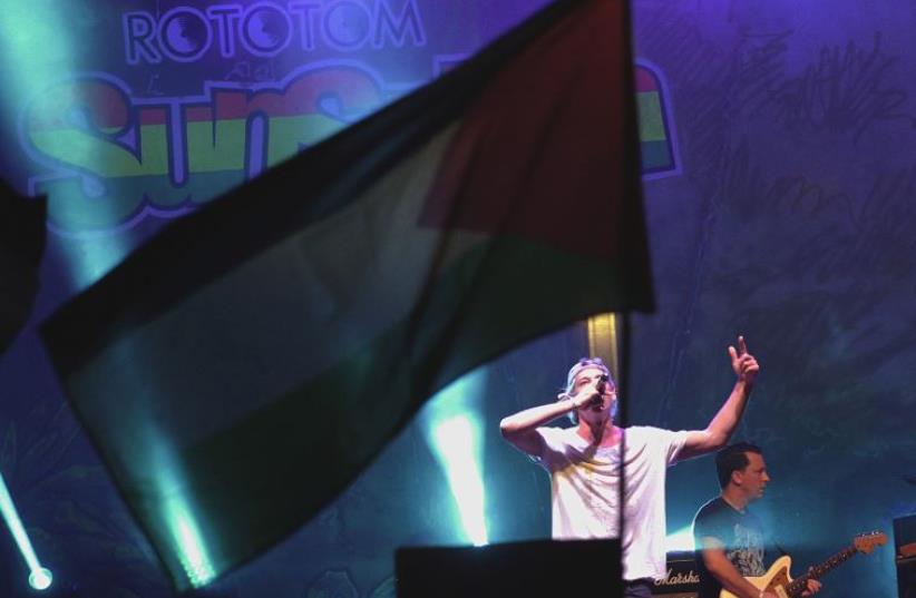 A Palestinian flag flies as Jewish musician Matisyahu performs on stage during the Rototom Sunsplash festival in Benicassim (photo credit: REUTERS)
