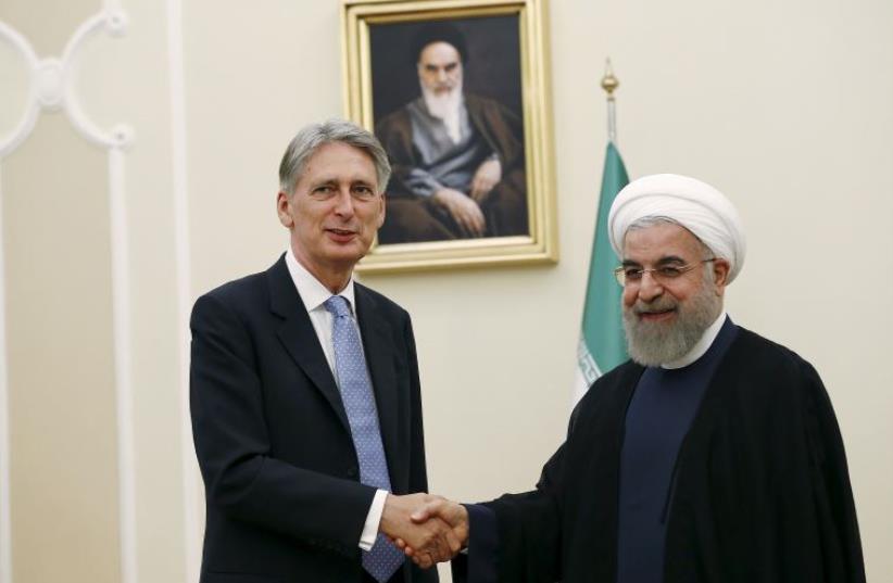 Britain's Foreign Secretary Philip Hammond (L) shakes hands with Iran's President Hassan Rouhani before a meeting at the President's Palace in Tehran, Iran (photo credit: REUTERS)
