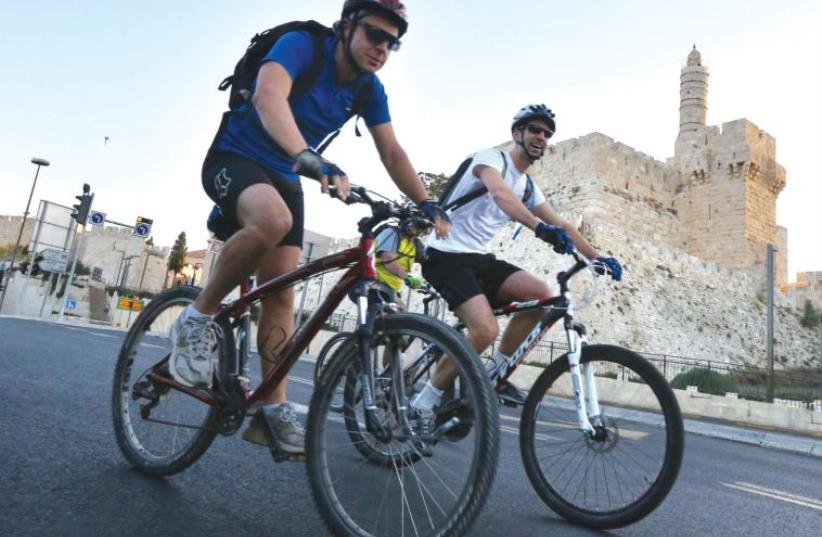 Taking part in the 2013 Gran Fondo Giro d’Italia charity bicycle race near the Old City walls, cyclists pass the Tower of David. (photo credit: MARC ISRAEL SELLEM/THE JERUSALEM POST)