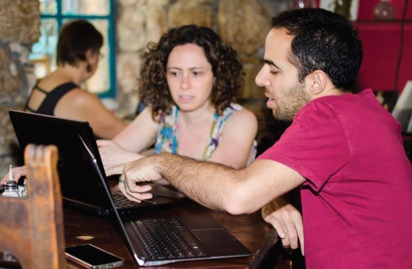 Deena Levenstein (left) gets ready to tap away on her laptop in Tmol Shilshom’s new hub (photo credit: OSHER SHNEOR BLOCH)