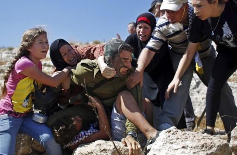 IDF soldier attacked by Palestinians, August 28, 2015 (photo credit: REUTERS)