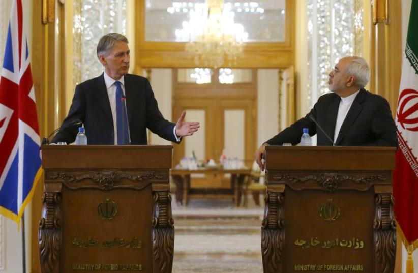Britain's Foreign Secretary Philip Hammond (L) and Iran's Foreign Minister Mohammad Javad Zarif speak during a news conference in Tehran (photo credit: REUTERS)