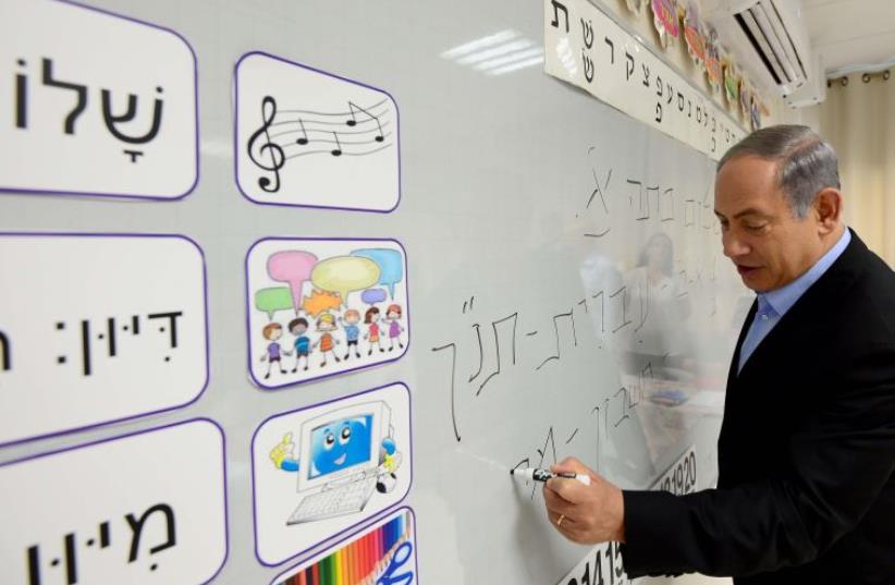 Netanyahu with first grade students in Ashdod (photo credit: UNITAR-UNOSAT / AFP)