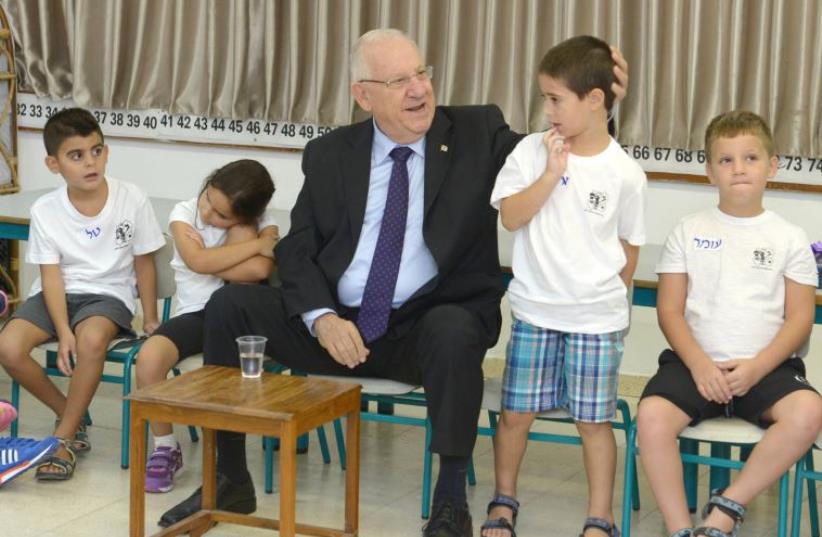 President Rivlin with first grade students in Ashdod (photo credit: UNITAR-UNOSAT / AFP)