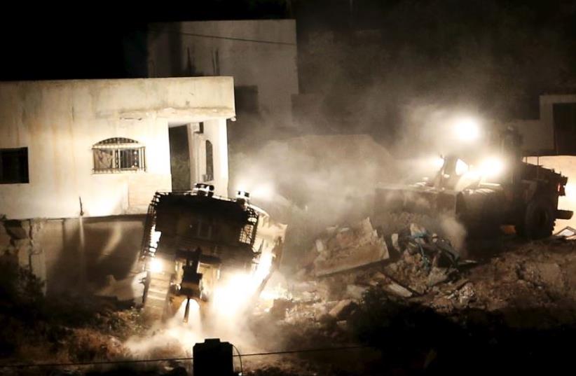 Israeli army machines demolish a Palestinian house during an Israeli raid in the West Bank city of Jenin (photo credit: REUTERS)
