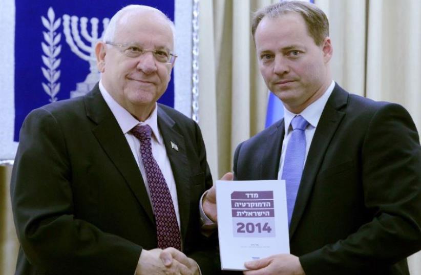 Yohanan Plesner, President of the Israel Democracy Institute, hands the 2014 Israel Democracy Index to President Reuven Rivlin at the President’s residence in Jerusalem (photo credit: MARK NEYMAN / GPO)