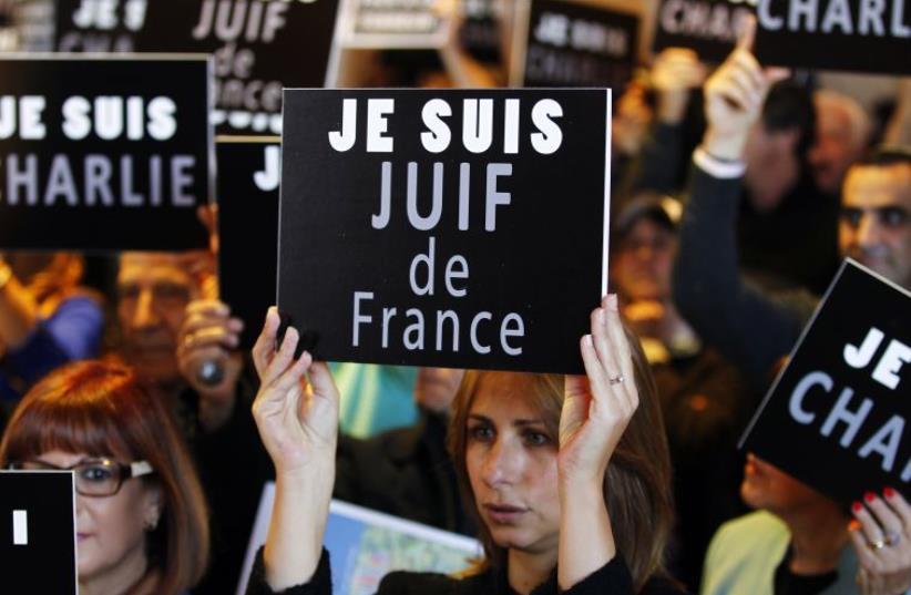 People hold up signs during a rally in Jerusalem, to show support for the French nation and the Jewish victims of terror (photo credit: REUTERS/Ronen Zvulun)
