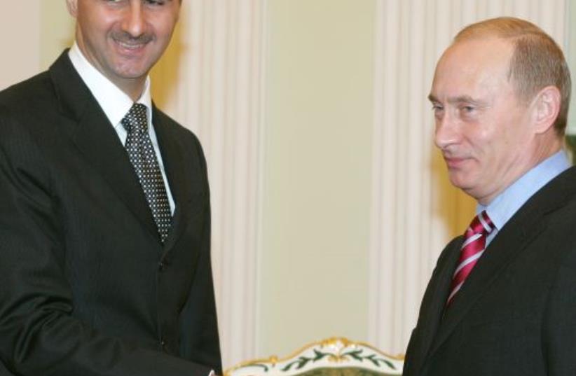 Russia's President Vladimir Putin (R) and Syrian President Bashar Assad shake hands as they meet in the Kremlin (photo credit: REUTERS)