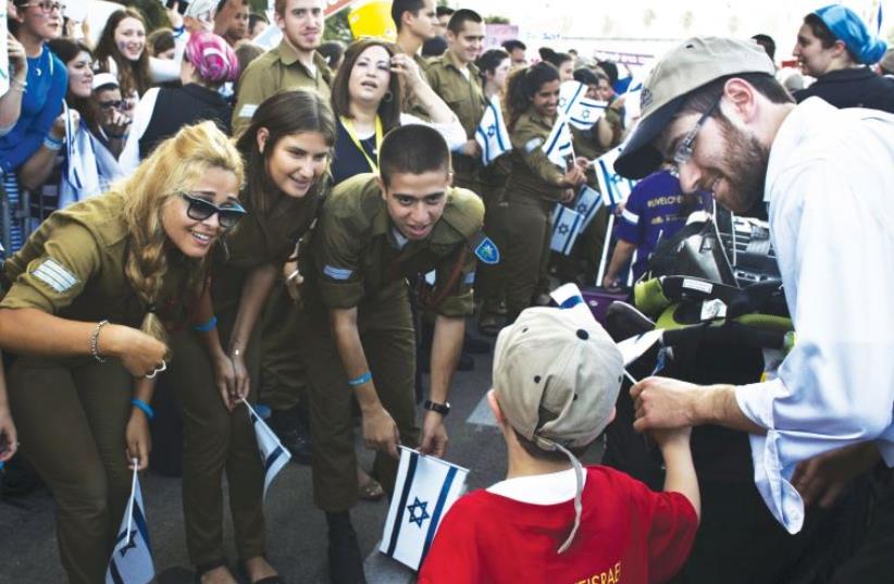 Soldiers greet newly arrived immigrants from North America at Ben-Gurion International Airport (photo credit: NIR ELIAS / REUTERS)