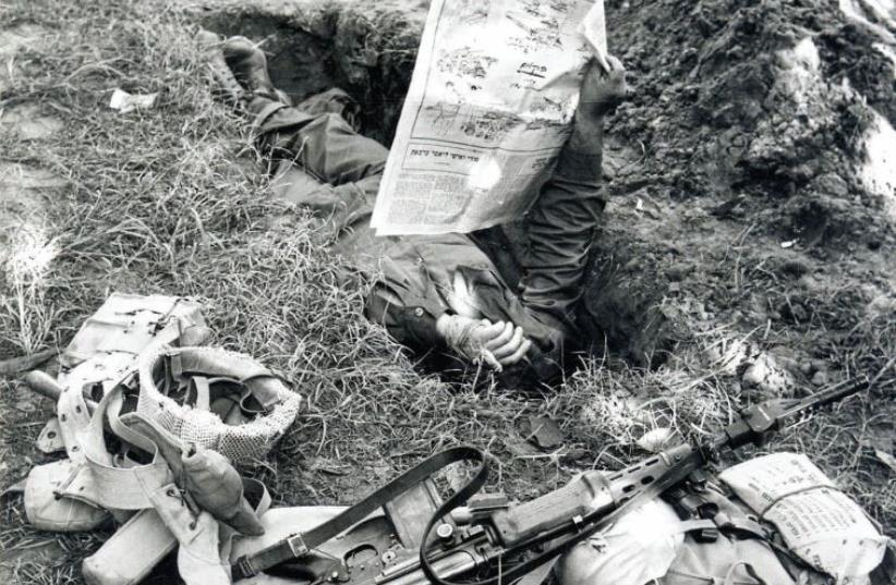 A soldier takes a break with a newspaper while stationed near the Suez canal (photo credit: JERUSALEM POST ARCHIVE)