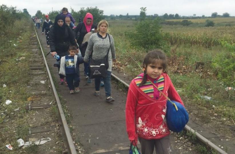 REFUGEES WALK along train tracks leading from Serbia into Hungary on Friday (photo credit: SETH J. FRANTZMAN)