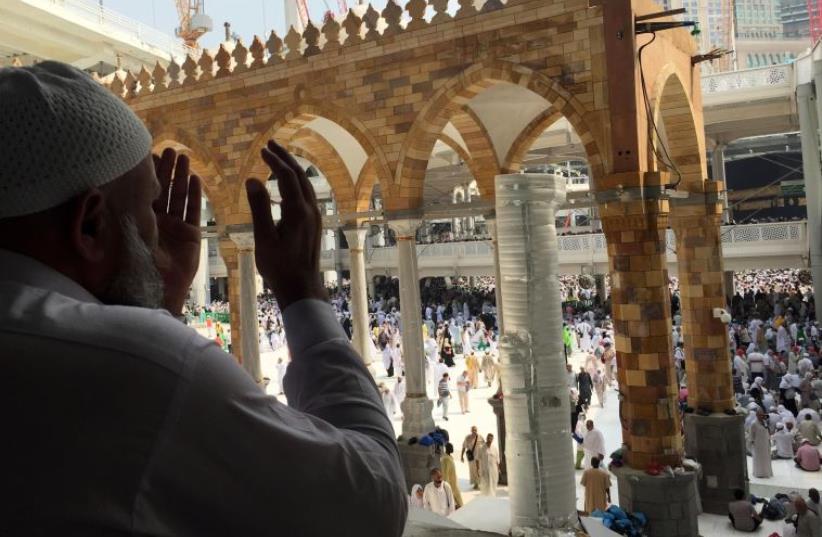 Muslim pilgrims pray at the Grand Mosque on September 14, 2015 in Saudi Arabia's holy Muslim city of Mecca. The hajj, a pillar of the Muslim religion, drew last year about two million faithful and is expected to start on September 21 (photo credit: AFP PHOTO)
