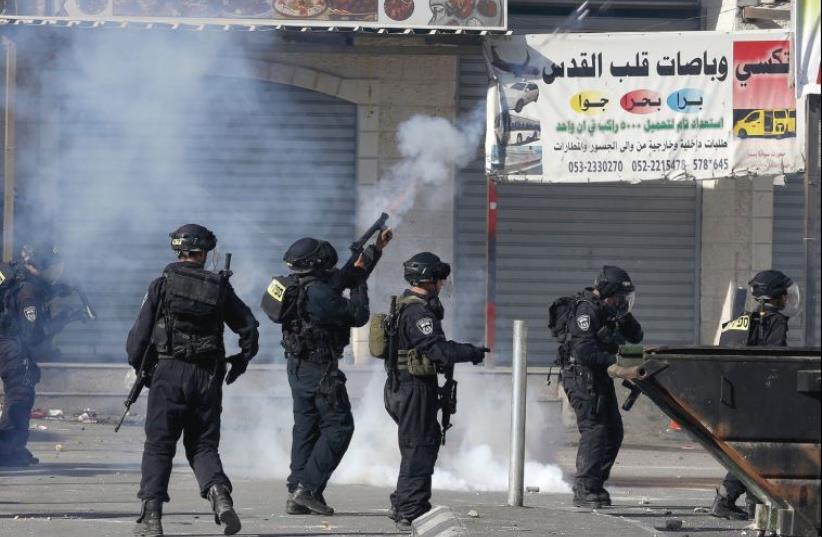 BORDER POLICEMEN fire tear gas at rock-throwers in the Shuafat refugee camp in northeastern Jerusalem on Friday (photo credit: REUTERS)
