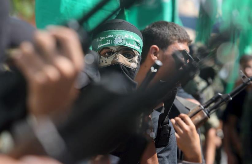Palestinian Hamas militants take part in a protest against the Israeli police raid on Jerusalem's al-Aksa mosque in Khan Yunis (photo credit: REUTERS)