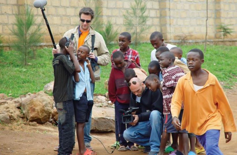 Ygal Egry (crouching) during filming in Kigali with sound engineer Frederic Cristea (photo credit: YGAL EGRY)