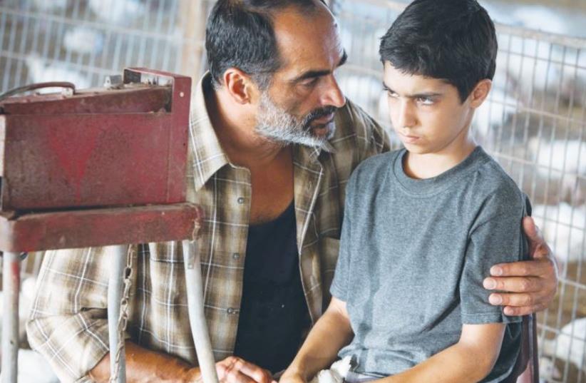 ACTOR NAVID NEGAHBAN puts his arm around Asher Avrahami in a scene from ‘Baba Joon,’ the Ophir Awards Best Picture winner (photo credit: Courtesy)