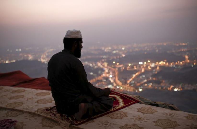 A Muslim pilgrim prays atop Mount Thor in the holy city of Mecca ahead of the annual hajj pilgrimage (photo credit: REUTERS)